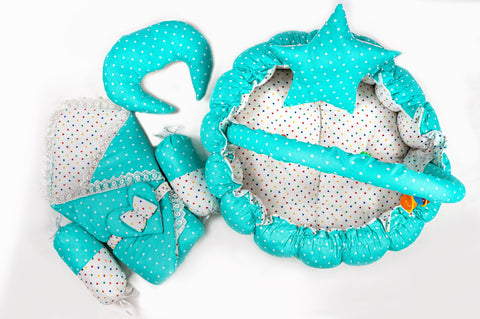 Soft baby snuggle bed with protective net and hanging rattle toys in green polka dot print