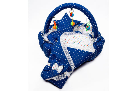 Soft baby snuggle bed with protective net and hanging rattle toys in dark blue polka dot print