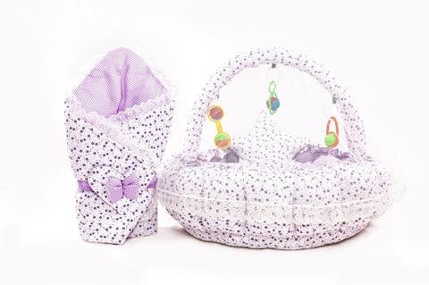 Soft baby snuggle bed with protective net and hanging rattle toys in purple flower print