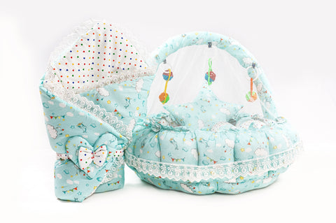 Soft baby snuggle bed with protective net and hanging rattle toys in green cloud print