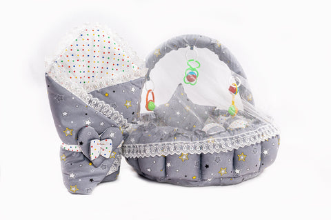 Soft baby snuggle bed with protective net and hanging rattle toys in grey star print