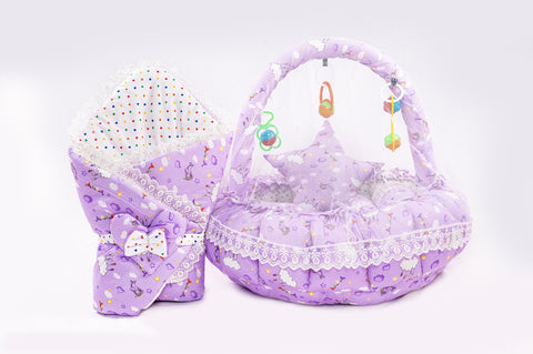 Soft baby snuggle bed with protective net and hanging rattle toys in purple cloud print