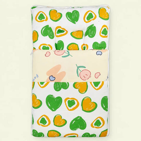 Soft cushioned baby carry nest laid flat unzipped in green and orange heart pattern